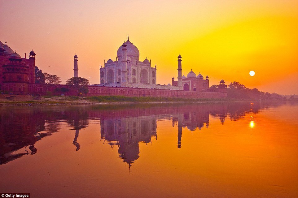 Khi mặt trời lặn sau lăng Taj Mahal của Ấn Độ, các mái vòm và tường cẩm thạch của công trình tuyệt mỹ này chuyển màu tím, giữa không gian lộng lẫy với ánh nắng màu cam ấn tượng.